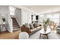 Cozy living room with a comfortable brown leather sofa, a modern rug, and access to the staircase and kitchen at 2347 N Pennsylvania St, Indianapolis, IN 46205