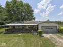 Home with a covered porch and an attached garage, with a blue sky and white clouds above at 2868 S 525 W, Trafalgar, IN 46181