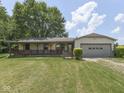 Charming home with a covered porch and an attached garage on a sunny day at 2868 S 525 W, Trafalgar, IN 46181