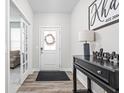 Welcoming entryway with wood floors, decorative console table, and a charming 'Welcome' sign at 3969 Canning St, Danville, IN 46122