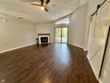 Spacious living room with dark wood flooring, a fireplace, a sliding door and a sliding barn door at 4049 Zinfandel Way, Indianapolis, IN 46254
