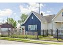 Exterior view of a charming blue home, showcasing its well-maintained yard and inviting curb appeal at 413 E Caven St, Indianapolis, IN 46225