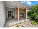 Inviting front porch with brick accents, white columns, and a welcoming entrance at 452 Southern Pines Dr, Whiteland, IN 46184