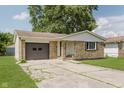 Charming single-story home with stone facade, attached garage, and well-maintained lawn at 5134 Rinehart Ave, Indianapolis, IN 46241
