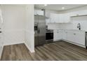 Bright kitchen features white cabinets, stainless steel appliances, and wood-look flooring at 5134 Rinehart Ave, Indianapolis, IN 46241