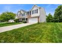 View of a two-story home with a long driveway leading to an attached two-car garage at 6848 Harriet Dr, Indianapolis, IN 46237