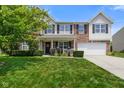 Attractive two-story home showcasing a brick facade, manicured lawn, and an attached two-car garage at 6848 Harriet Dr, Indianapolis, IN 46237