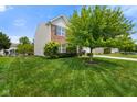 Well-maintained home with a lush green lawn, mature tree, and brick accents at 6848 Harriet Dr, Indianapolis, IN 46237