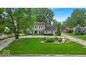 Traditional two-story home with a lush green lawn and manicured landscaping, creating a picturesque setting at 7502 Colony Cir, Indianapolis, IN 46260