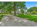 Charming two-story home featuring mature trees and established landscaping, surrounded by a well-maintained lawn at 7502 Colony Cir, Indianapolis, IN 46260