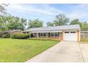 Single-story brick home featuring a covered porch, attached garage, and a green front lawn at 814 N Noble St, Greenfield, IN 46140