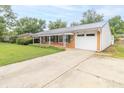 Single-story brick home with covered porch, attached garage, and a concrete driveway at 814 N Noble St, Greenfield, IN 46140