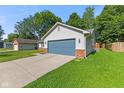 Cozy single-story home featuring a blue garage door, light siding, brick accents, and green lawn at 834 Delray Dr, Indianapolis, IN 46241