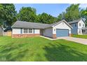 Traditional single-story home with blue garage door, siding, brick accents, and well-maintained lawn at 834 Delray Dr, Indianapolis, IN 46241