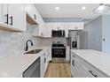 Modern kitchen with white cabinetry, stainless steel appliances, stylish backsplash, and an island, ideal for cooking at 8355 Fieldfare Way, Indianapolis, IN 46237