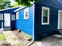 Home's side elevation with white trim around the windows and doors at 94 N Routiers Ave, Indianapolis, IN 46219