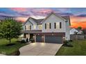 Stunning two-story home exterior with a two-car garage and vibrant sky at dusk at 9724 Brooks Dr, Fishers, IN 46055