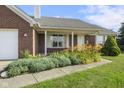 Charming red brick home with lovely landscaping and a well-maintained lawn at 1016 W Creek Ridge Dr, Fountaintown, IN 46130