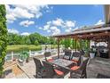 Outdoor patio with elegant seating and a serene view of a pond and lush greenery at 10758 Cyrus Dr, Indianapolis, IN 46231