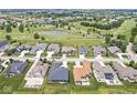 An aerial view showcases homes in a community with a golf course and ponds at 1165 Maclaren Ct, Franklin, IN 46131