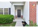 Inviting front porch with black door, brick accents, and well-kept landscaping at 12604 Buck Run Dr, Noblesville, IN 46060