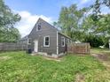 Backyard view of a gray home with a small door and wooden fence at 1601 E 44Th St, Indianapolis, IN 46205