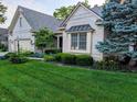 Beautiful brick home featuring lush green lawn, mature landscaping, and an inviting architectural design at 16254 Quartz Dr, Noblesville, IN 46060