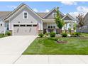 Charming home featuring a two-car garage, landscaped lawn, brick accents and cozy front porch with rocking chairs at 19959 Cowie Ln, Westfield, IN 46074