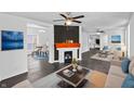 Bright living room featuring a modern fireplace, sleek dark floors and an open layout to the dining area at 2001 S Jefferson St, Muncie, IN 47302
