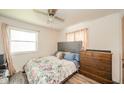 A serene bedroom is showcased with a comfortable bed, soft lighting, and complemented by a dresser and ceiling fan at 2113 W Barcelona Dr, Muncie, IN 47304