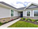 Inviting front entrance with stone accents, manicured flower beds, and a charming walkway at 2500 Sand Hollow Dr, Lebanon, IN 46052