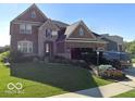 Elegant two-story brick home boasting a well-manicured lawn and an attached two-car garage at 2783 W High Grove Cir, Zionsville, IN 46077