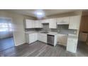 Modern kitchen featuring white cabinets, granite countertops, stainless steel appliances, and gray subway tile backsplash at 2807 Carla Ct, Indianapolis, IN 46219
