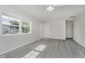 Bright living room with grey wood-look flooring, white walls, and natural light from the windows at 2807 Carla Ct, Indianapolis, IN 46219