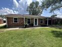 Charming brick home featuring a well-manicured lawn and cozy front porch seating area at 2845 12Th St, Columbus, IN 47201