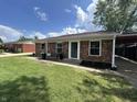 Charming brick home featuring a well-manicured lawn and cozy front porch seating area at 2845 12Th St, Columbus, IN 47201