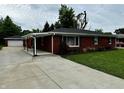 Charming red brick ranch home featuring a long driveway and a detached two-car garage at 5015 Nowland Ave, Indianapolis, IN 46201