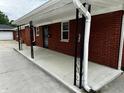 Exterior view of the home highlighting the covered walkway and red brick siding at 5015 Nowland Ave, Indianapolis, IN 46201