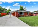 Side view of brick house with driveway leading to detached garage and covered entry at 5015 Nowland Ave, Indianapolis, IN 46201