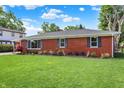 Brick house on a grassy lot, enhanced by a garden and manicured landscape at 5015 Nowland Ave, Indianapolis, IN 46201