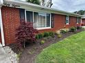 Close up of the front of the home with beautiful landscaping and a red brick exterior at 5015 Nowland Ave, Indianapolis, IN 46201
