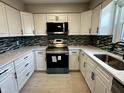 Bright kitchen featuring white cabinets, modern appliances, updated countertops, and decorative tile backsplash at 5015 Nowland Ave, Indianapolis, IN 46201