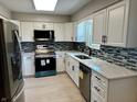 Modern kitchen with stainless steel appliances, white cabinets, stylish backsplash, and bright lighting at 5015 Nowland Ave, Indianapolis, IN 46201