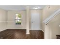 Bright entryway featuring dark wood-look floors, a white door, and a view of the front yard through the window at 5519 Apple Branch Way, Indianapolis, IN 46237