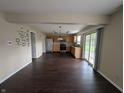 Open-concept view of the kitchen featuring stainless steel appliances, wood cabinets, and dark floors at 5519 Apple Branch Way, Indianapolis, IN 46237