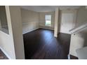 Inviting living room with dark floors, neutral walls, white trim, and natural light shining through the window at 5519 Apple Branch Way, Indianapolis, IN 46237