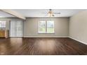 Spacious living room featuring dark wood-look floors, neutral paint, and natural light from the window at 5519 Apple Branch Way, Indianapolis, IN 46237