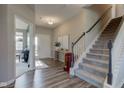 Open entryway with wood-look flooring, stairs to the second floor, and a welcoming front door at 5527 Mahogany Dr, Noblesville, IN 46062