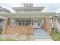 Charming two-story home with a welcoming front porch and brick accents at 555 N Oakland Ave, Indianapolis, IN 46201