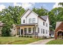Beautiful two-story home showcasing a covered front porch and neat landscaping at 5678 N College Ave, Indianapolis, IN 46220